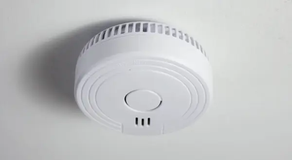 Ein weißer Funkrauchmelder an der Decke. Mögliche Nachteile von Funkrauchmeldern sind die Abhängigkeit von Batterien und Funkstörungen.