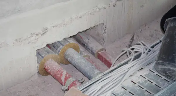 Rohre und Kabel werden für den Brandschutz auf Baustellen vorbereitet. Isolierte Rohre und Kabelbündel liegen bereit.