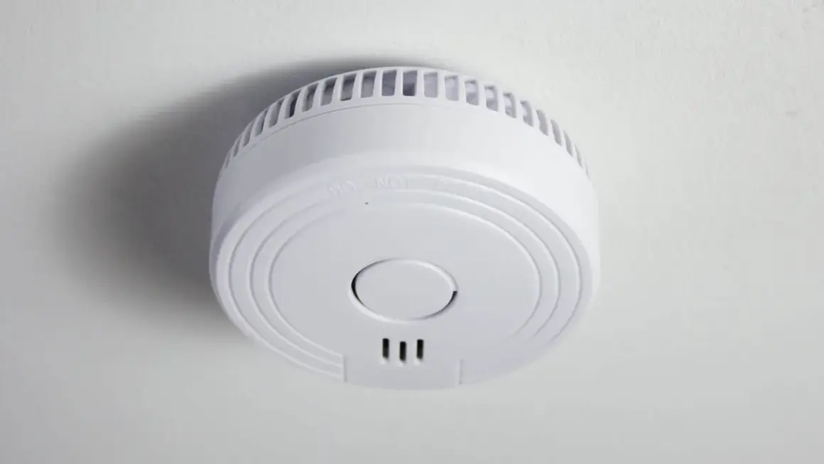 Ein weißer Funkrauchmelder an der Decke. Mögliche Nachteile von Funkrauchmeldern sind die Abhängigkeit von Batterien und Funkstörungen.