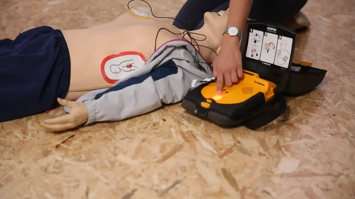 Schulung: Ein Defibrillator wird an einer Übungspuppe angewendet. Die Defibrillator-Pflicht ist wichtig für Erste Hilfe.