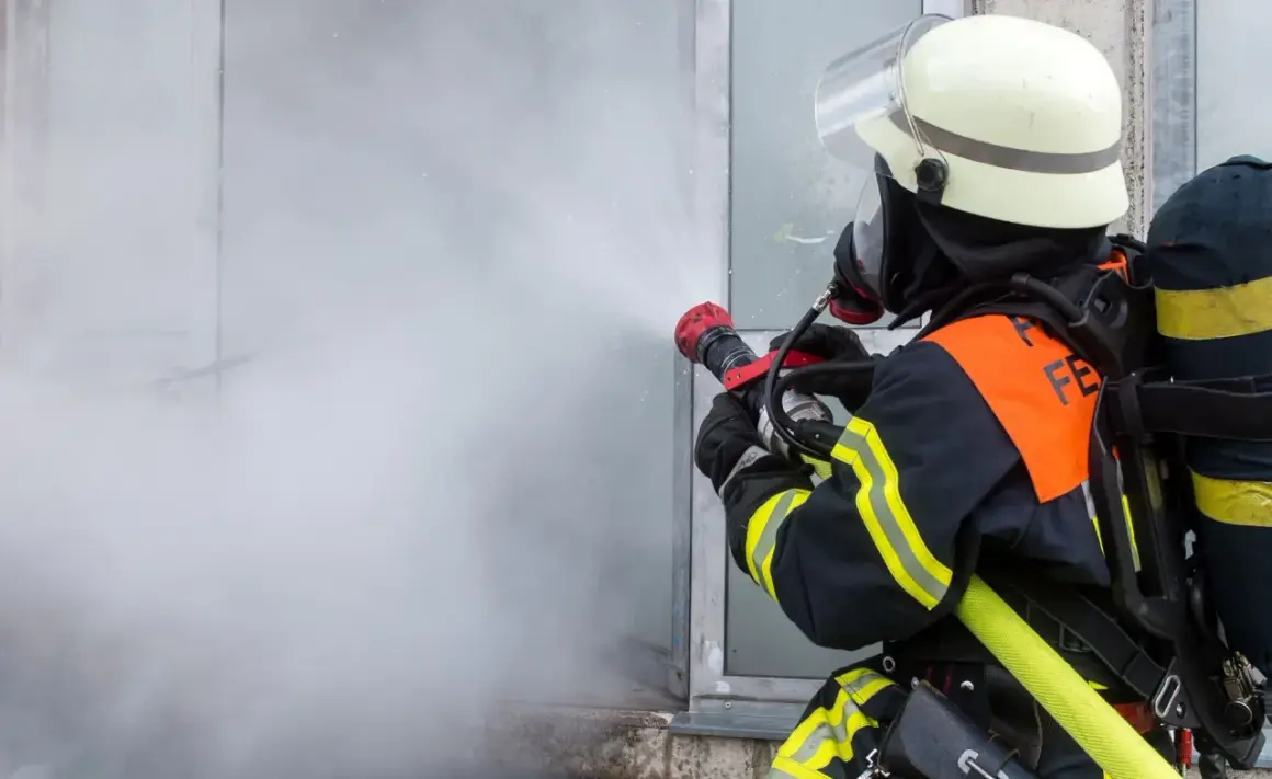Feuerwehrmann im Einsatz mit Sprühstrahl, ein Beispiel für die vielfältigen Berufe bei der Feuerwehr.