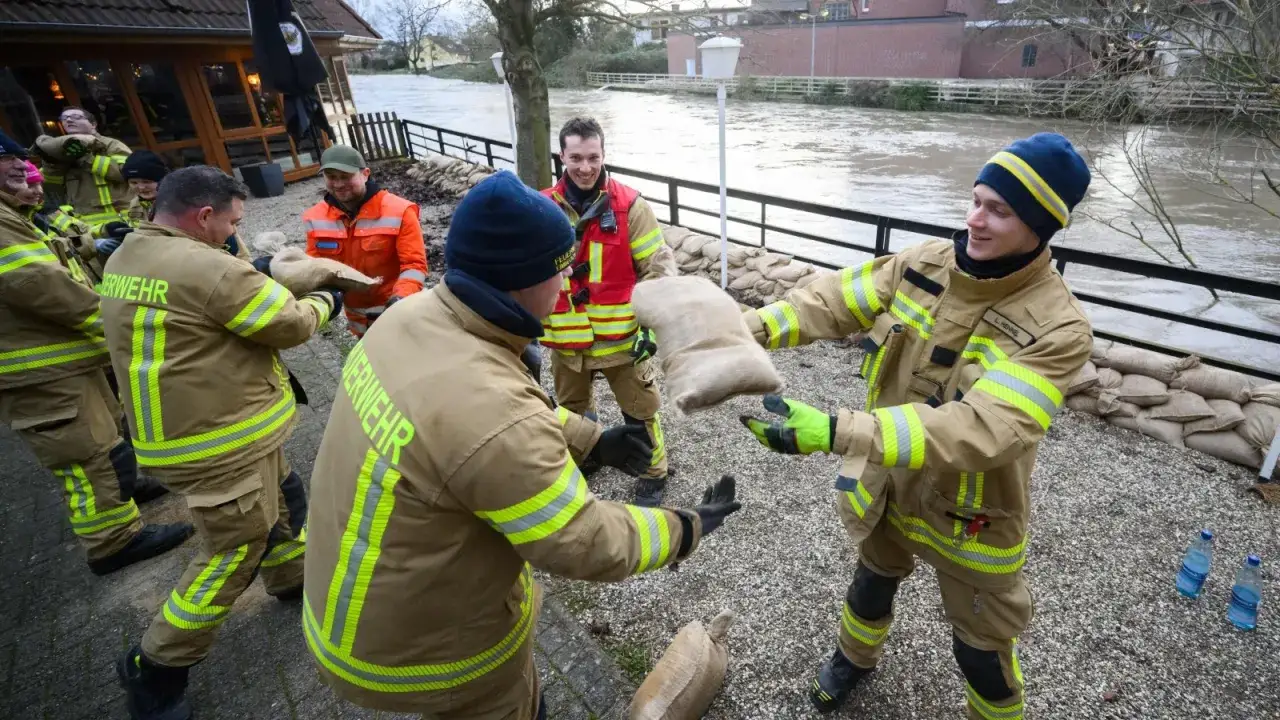 Feuerwehrleute in Niedersachsen bauen Sandsackbarrieren gegen Hochwasser. Das Feuerwehrgesetz Niedersachsen regelt solche Einsätze.