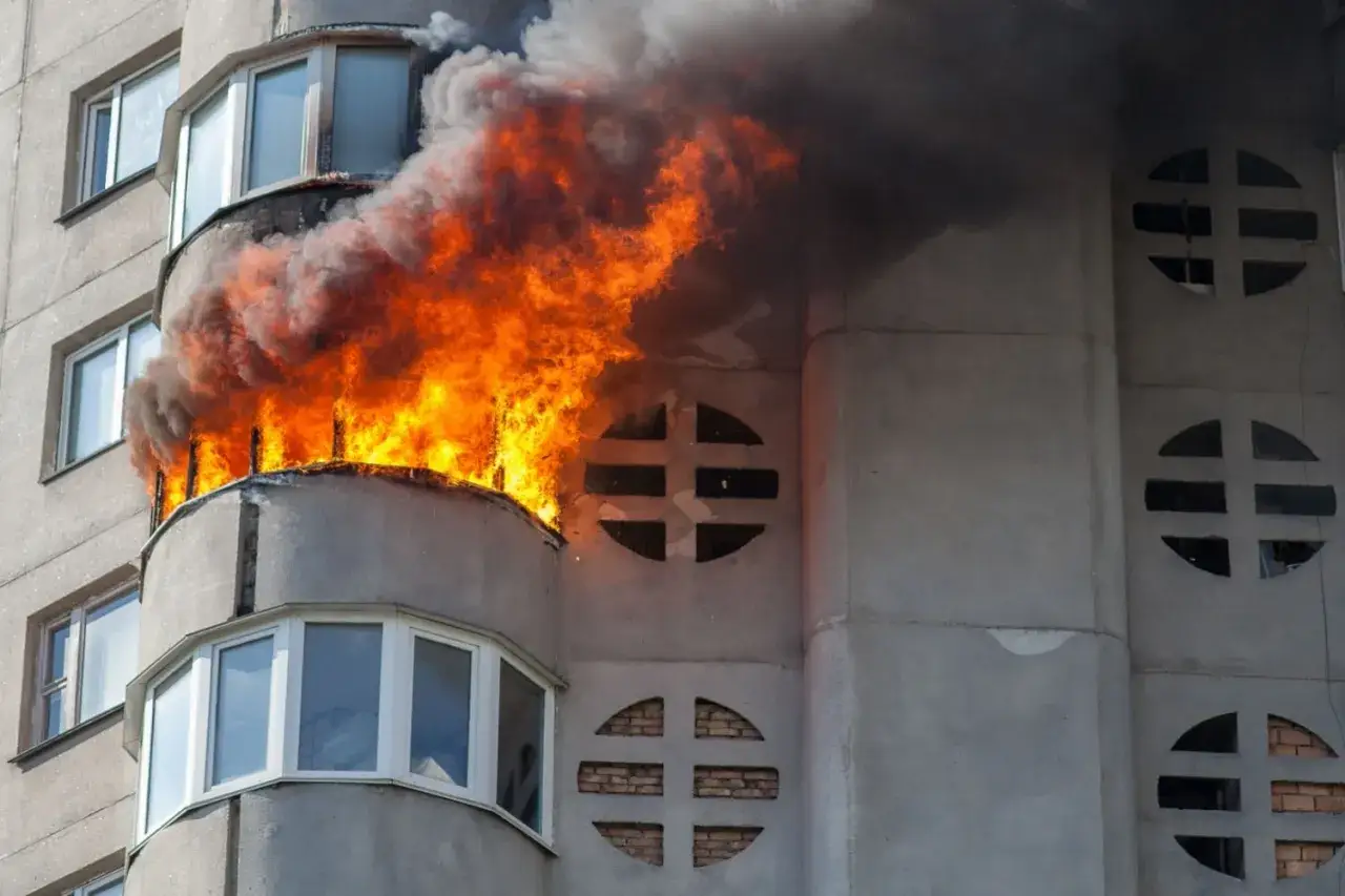 Ein Balkon brennt lichterloh, Rauch steigt auf. Die Frage, welche Versicherung zahlt bei Brand in Mietwohnung, ist hier relevant.