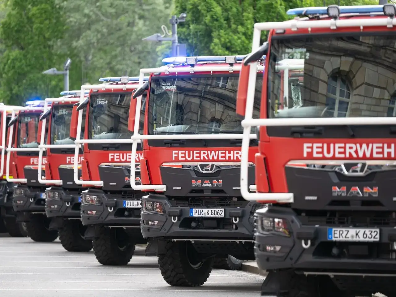 Reihe von roten Feuerwehrfahrzeugen, bereit f&uuml;r den Katastrophenschutz.