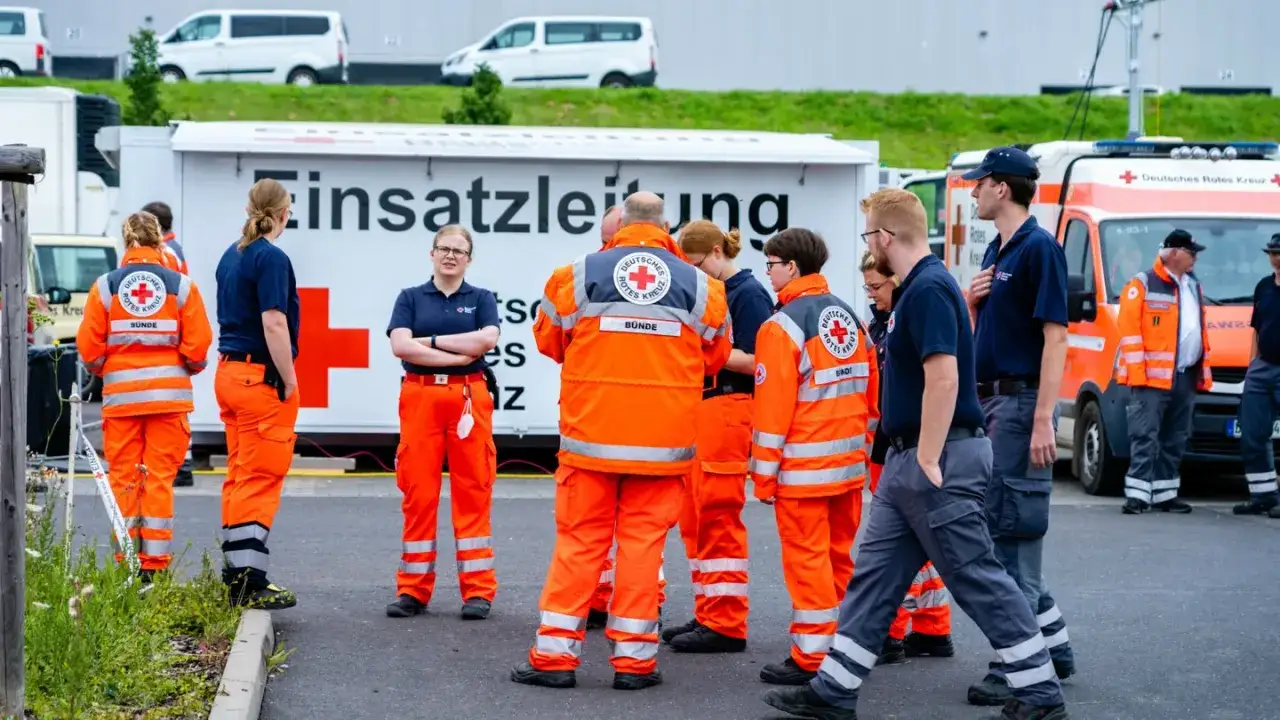 Einsatzkräfte des Deutschen Roten Kreuzes (DRK) in leuchtenden Einsatzjacken und Hosen, bereit für ihren Dienst.