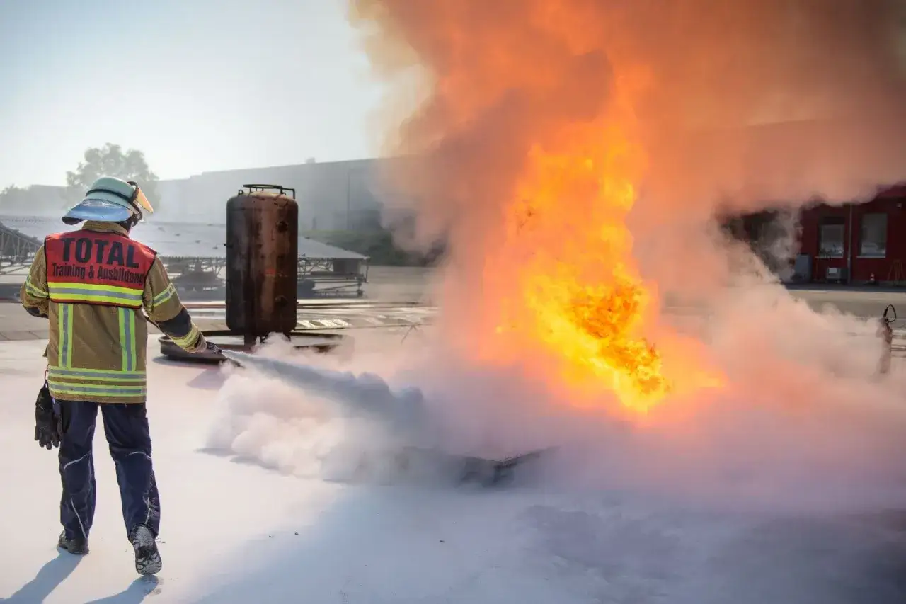 Brandschutzhelfer-Ausbildung: Ein Feuerwehrmann l&ouml;scht einen Brand. Wer darf Brandschutzhelfer ausbilden? Qualifizierte Trainer!
