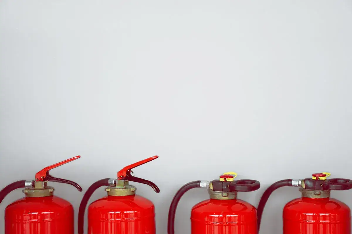 Vier rote Feuerl&ouml;scher stehen nebeneinander. Wichtig f&uuml;r den Brandschutz in der Gastronomie.