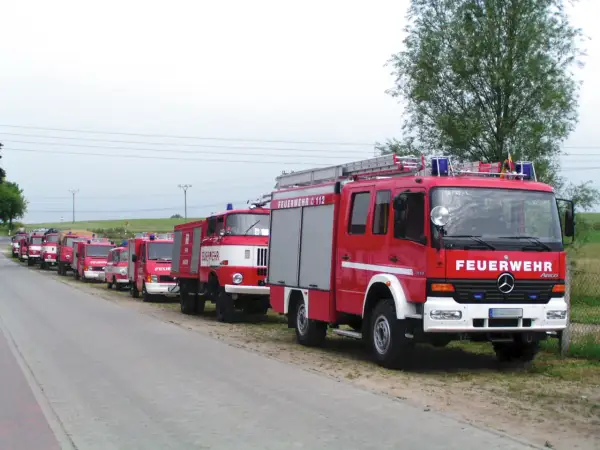 Reihe von roten Feuerwehrfahrzeugen, darunter 9 Fahrzeugtypen der Feuerwehr, bereit für den Einsatz.