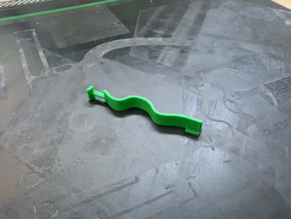 Grüne ista rauchmelder plombe, die an einem grauen Untergrund liegt.