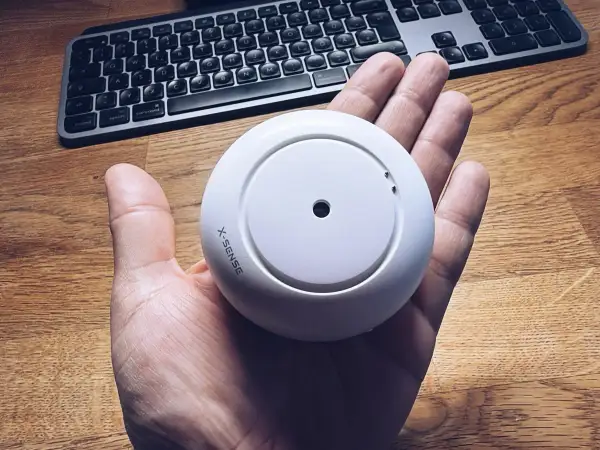 Rauchmelder von X-Sense in der Hand, bereit für die Integration in Home Assistant.