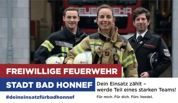 Drei lächelnde Mitglieder der freiwilligen Feuerwehr Bad Honnef posieren vor einem Feuerwehrauto. Sie werben für die Freiwillige Feuerwehr.